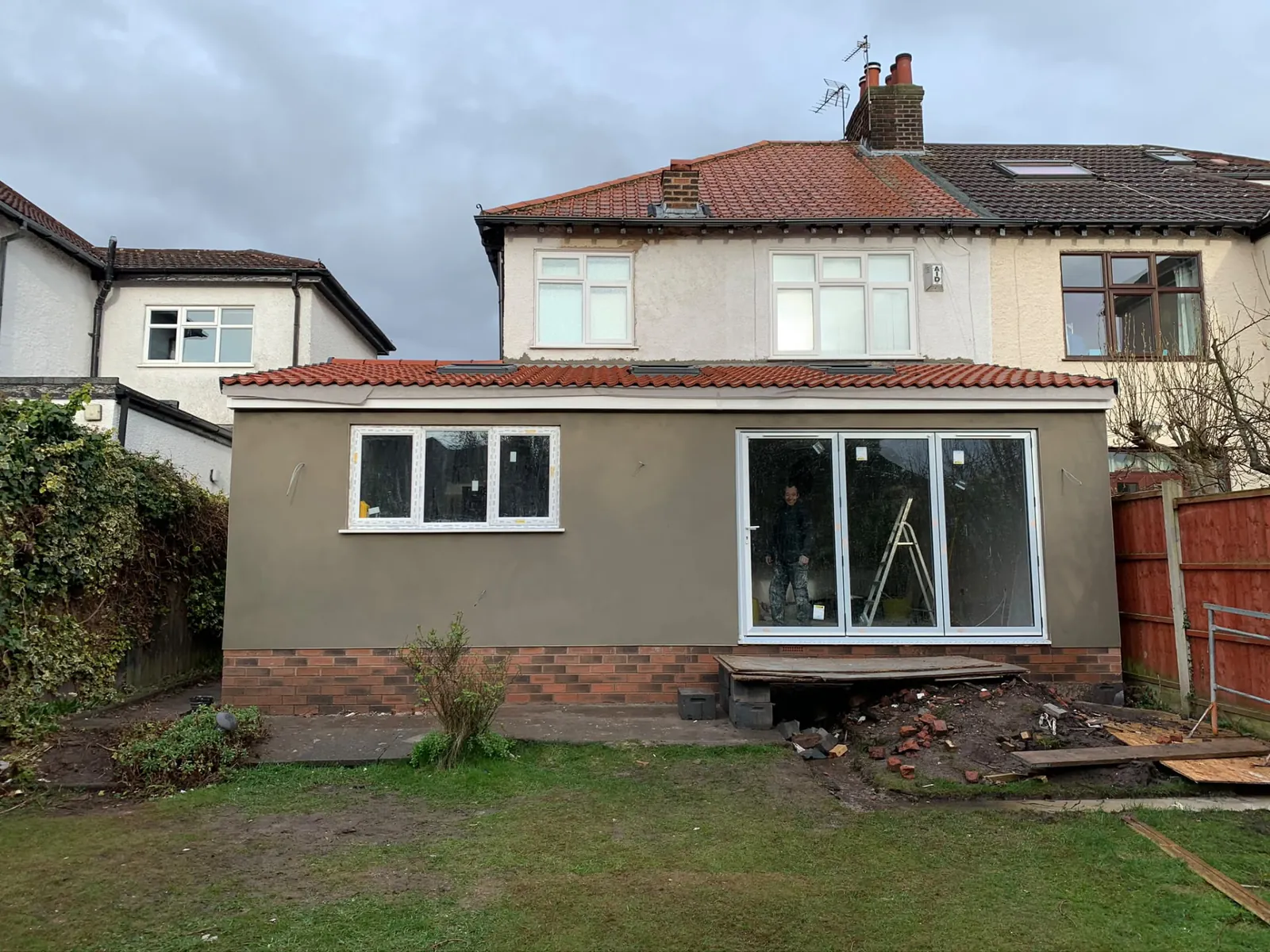 Rendered single-storey rear extension with bi-fold doors and roof lights nearing completion