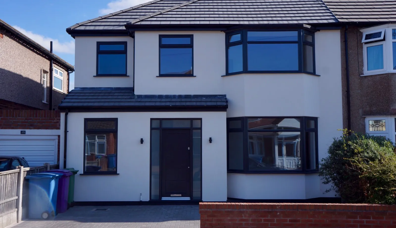 After: front extension with white render and dark framed windows