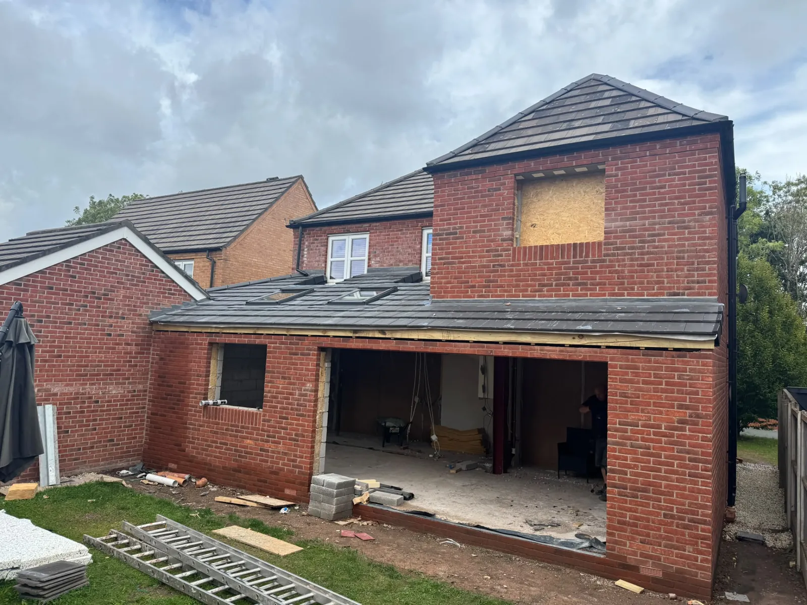 Two-storey brick rear extension under construction with new tiled roof and roof lights
