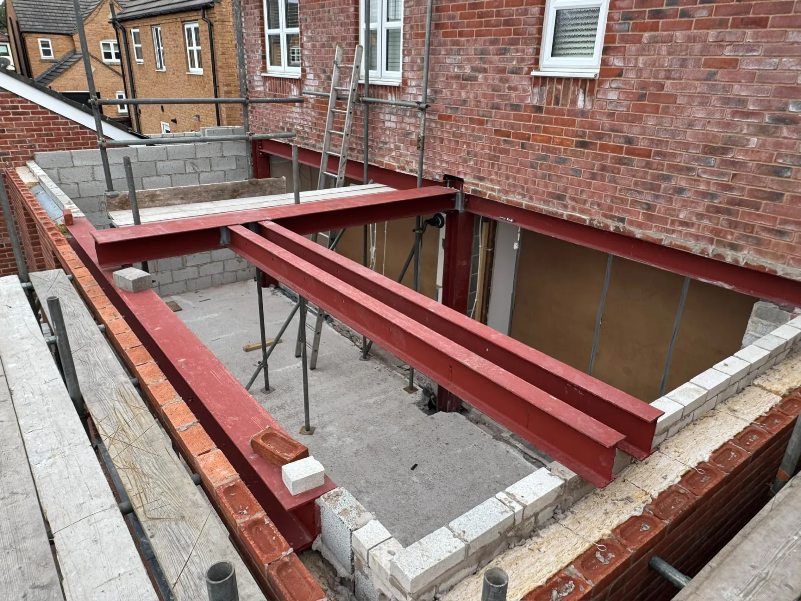 Structural steel beams and blockwork walls inside a house extension build