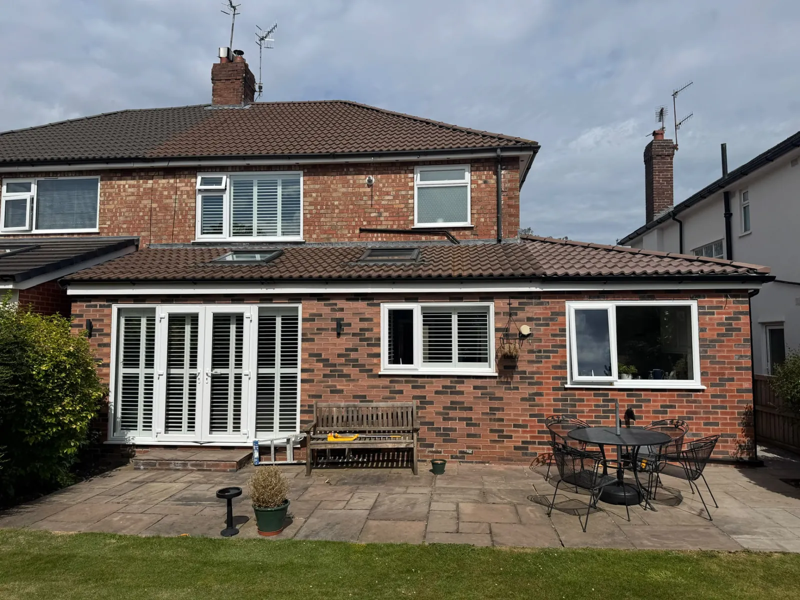 Finished brick rear extension with patio doors opening onto a new paved patio