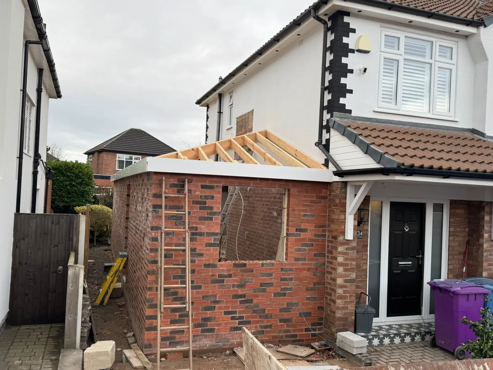 Small brick extension under construction at the side of a house